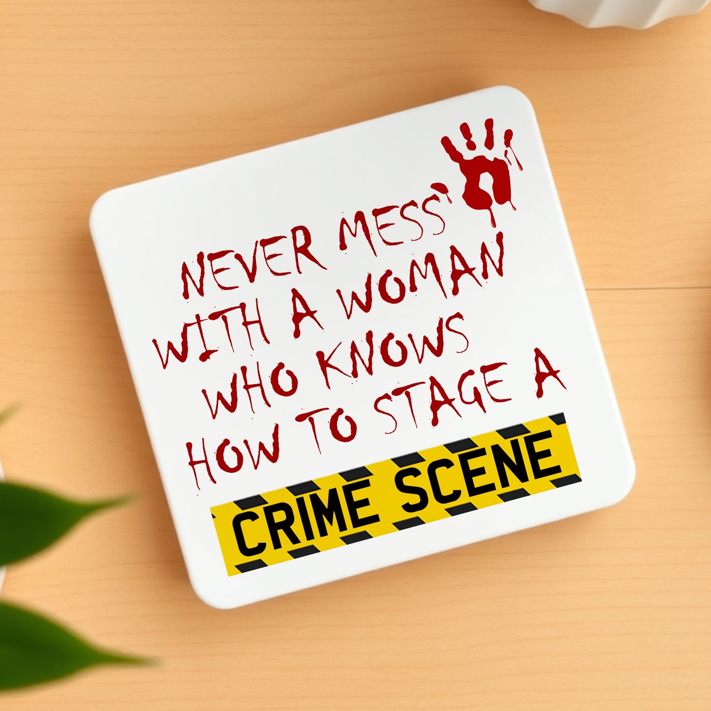 Coaster with humorous text and graphic on a wooden surface