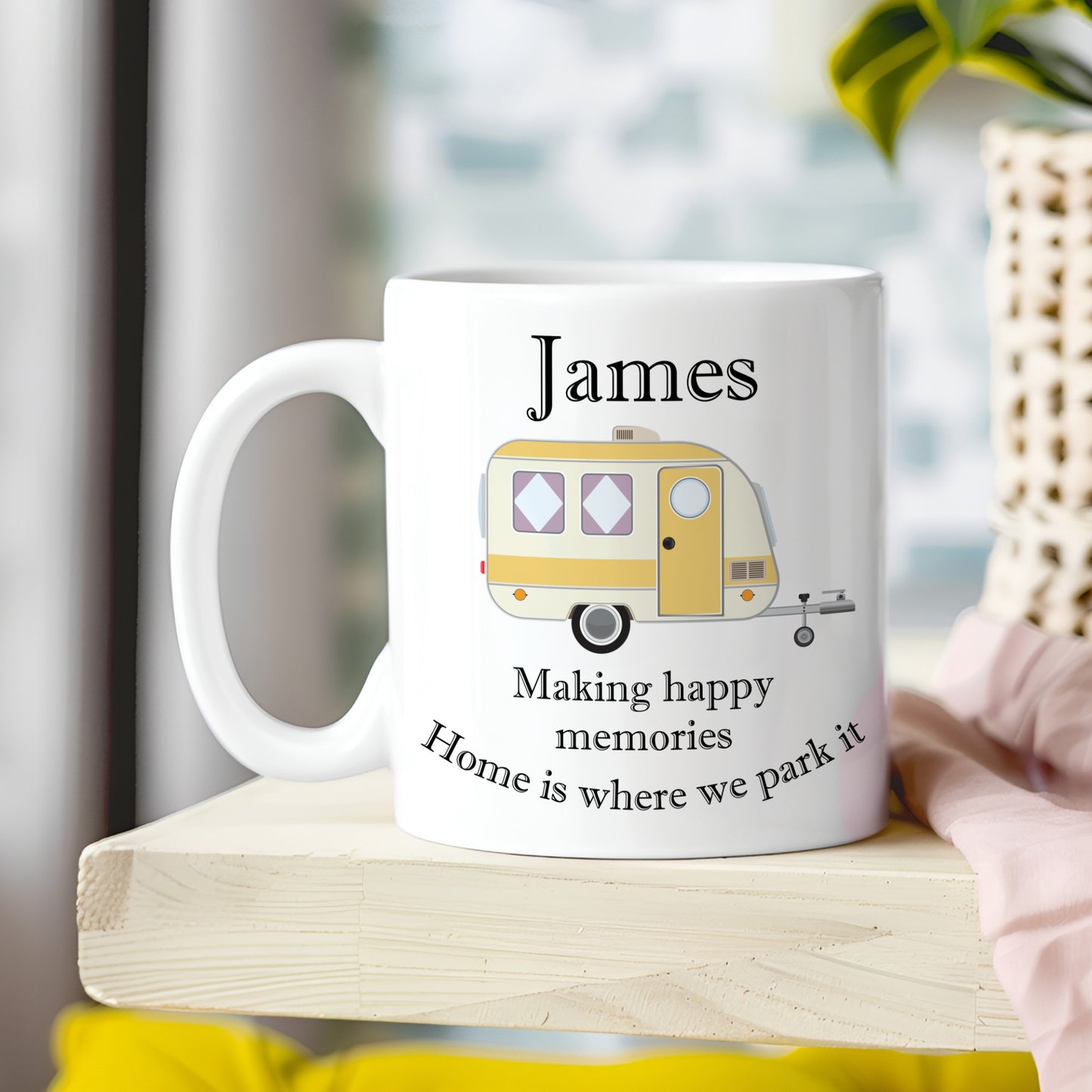 White mug with a camper design and text on a wooden surface