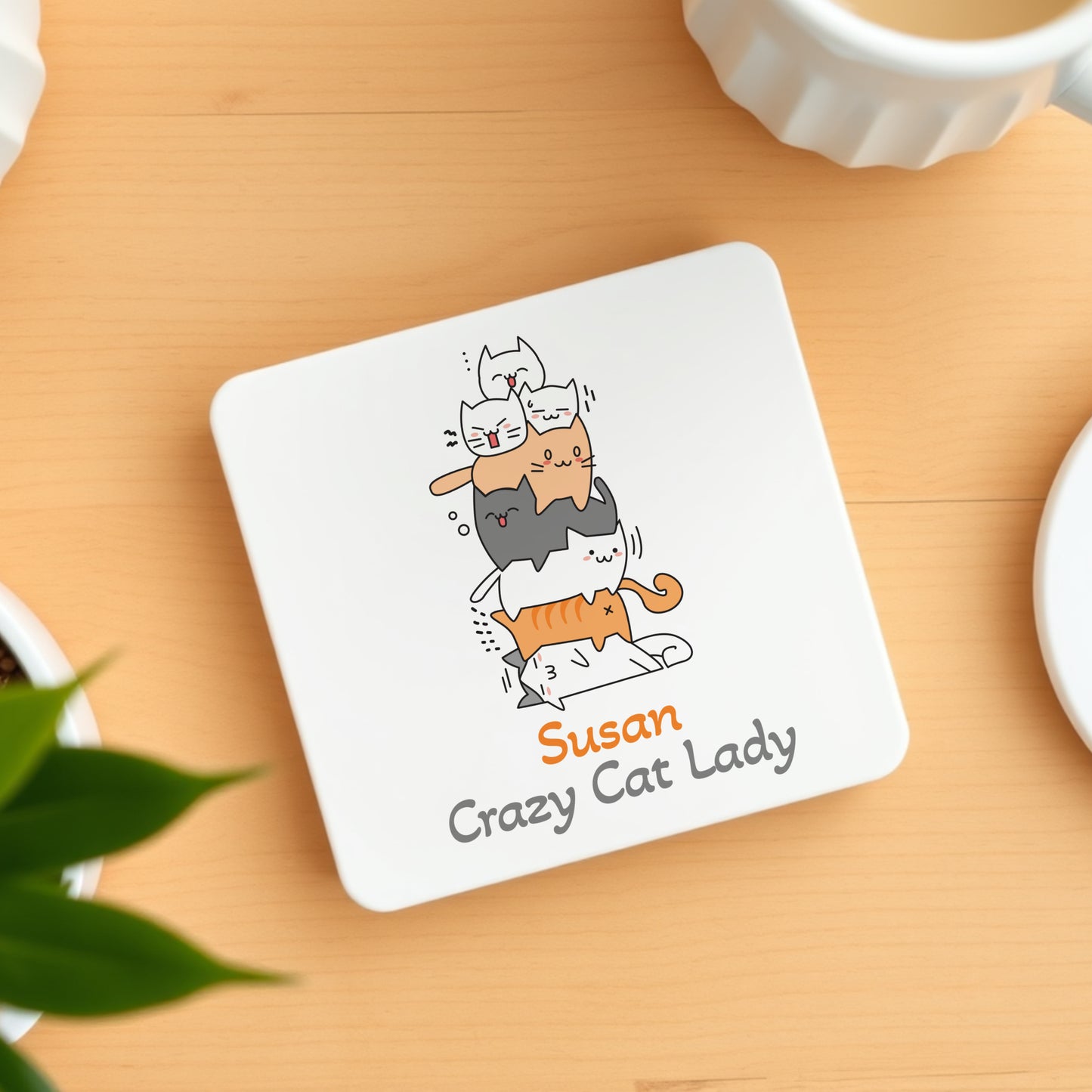 Coaster with cartoon cats and 'Susan Crazy Cat Lady' text on a wooden surface