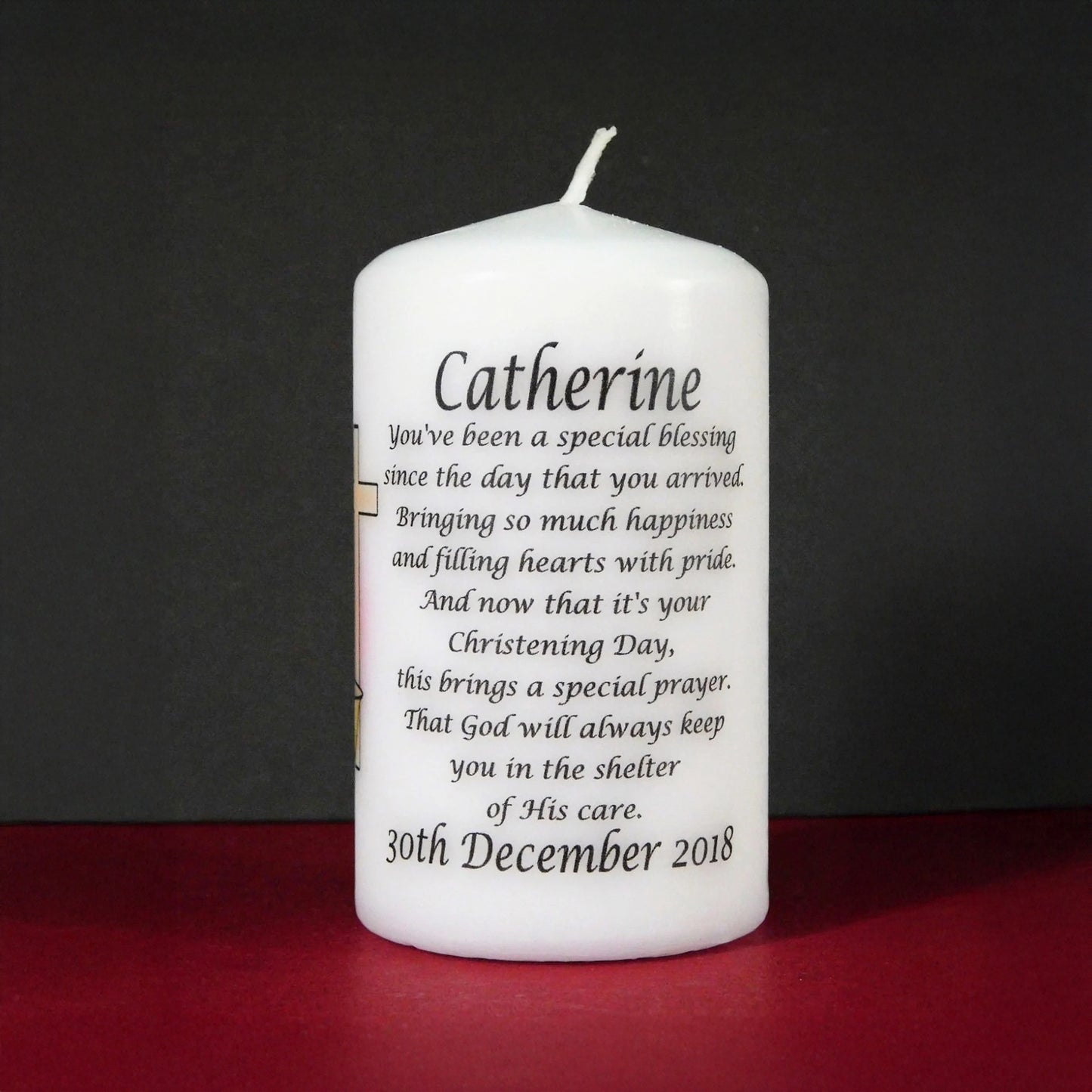 White candle with personalized text on a dark background