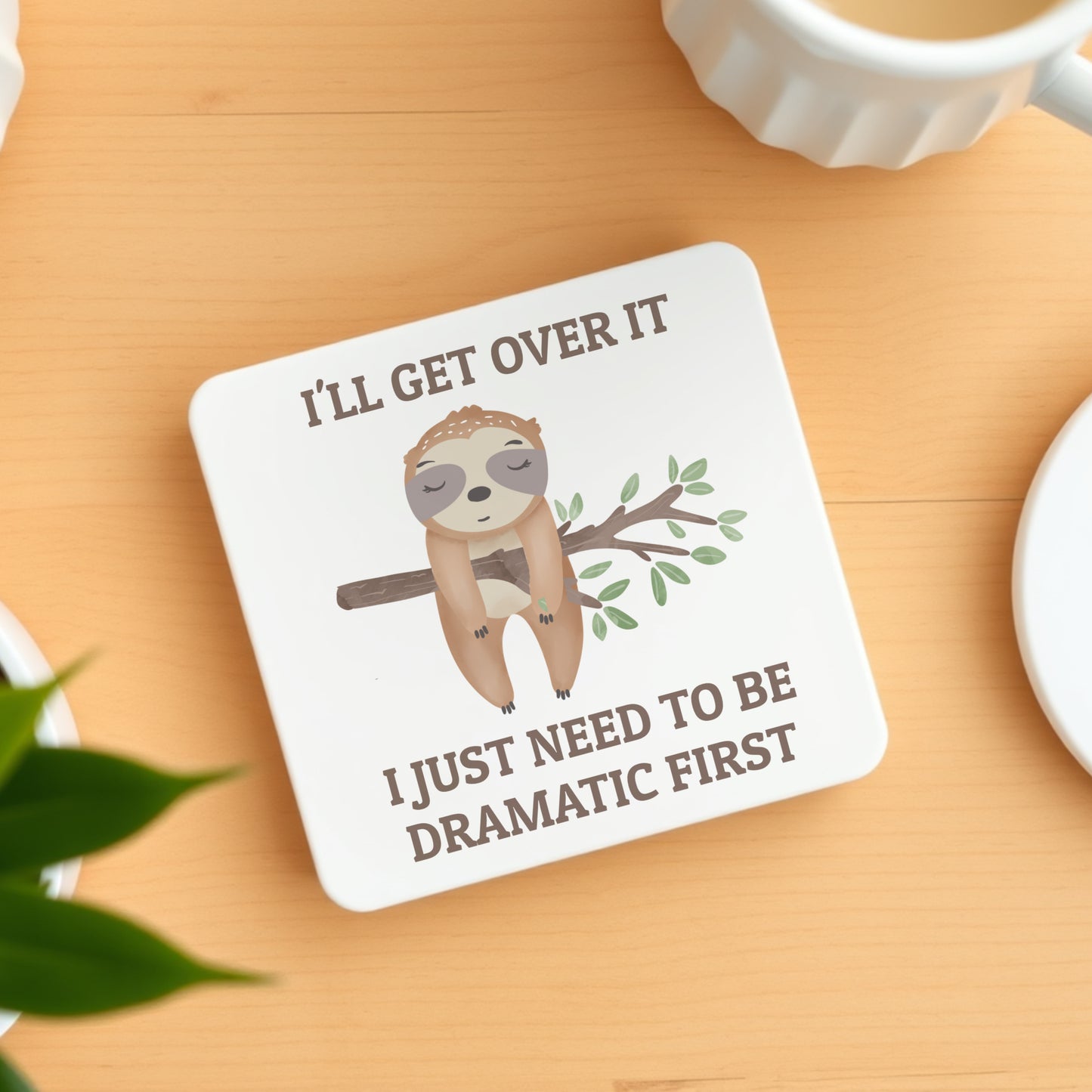 Coaster with sloth illustration and humorous text on a wooden surface
