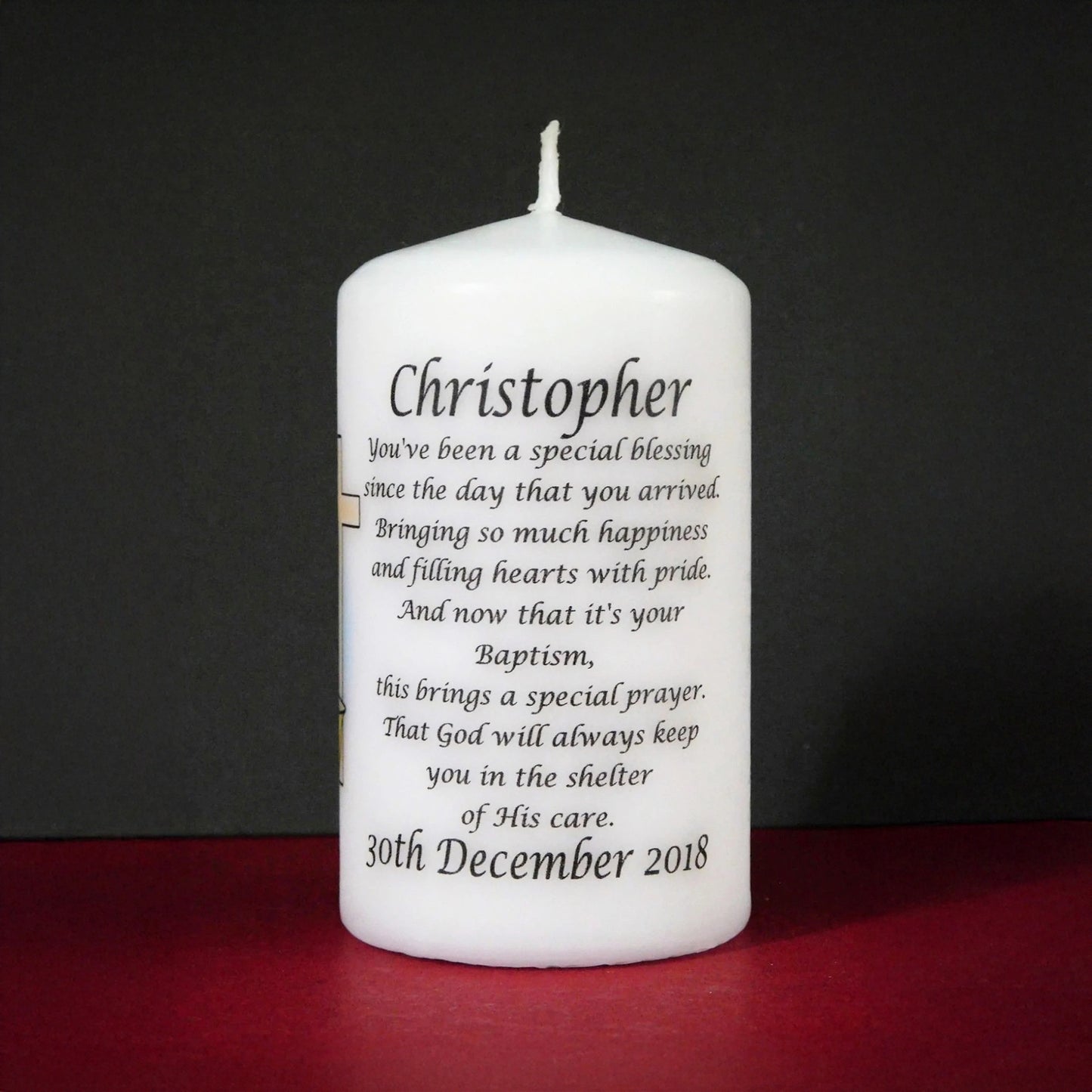White candle with personalized text on a black background