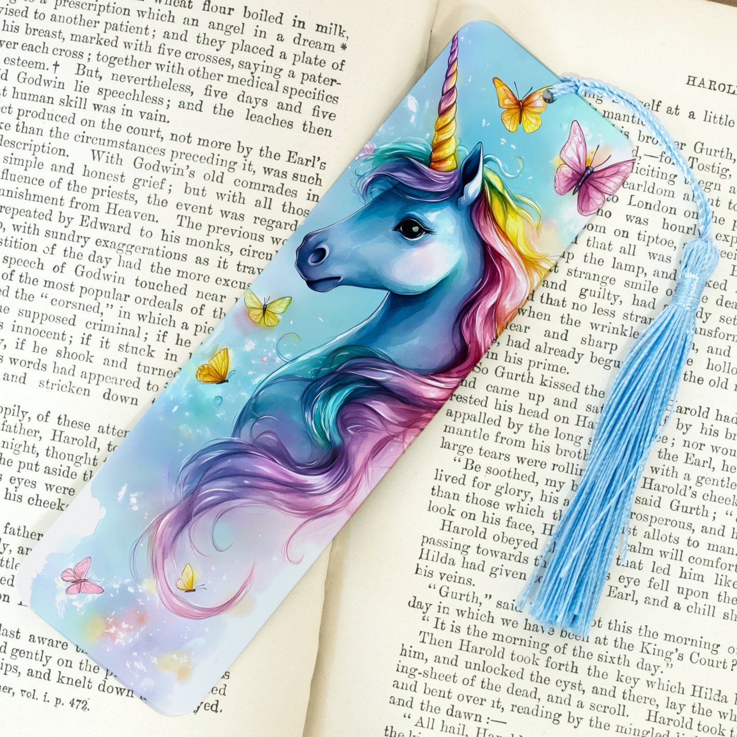 Colorful unicorn bookmark with butterflies on an open book
