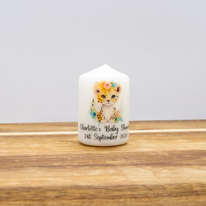 Decorative candle with a leopard design and text on a wooden surface