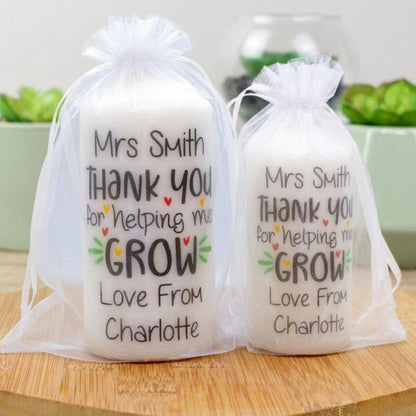 Two personalised candles with the phrase 'Thank You For Helping Me Grow', with a space for a custom name, presented in clear packaging.