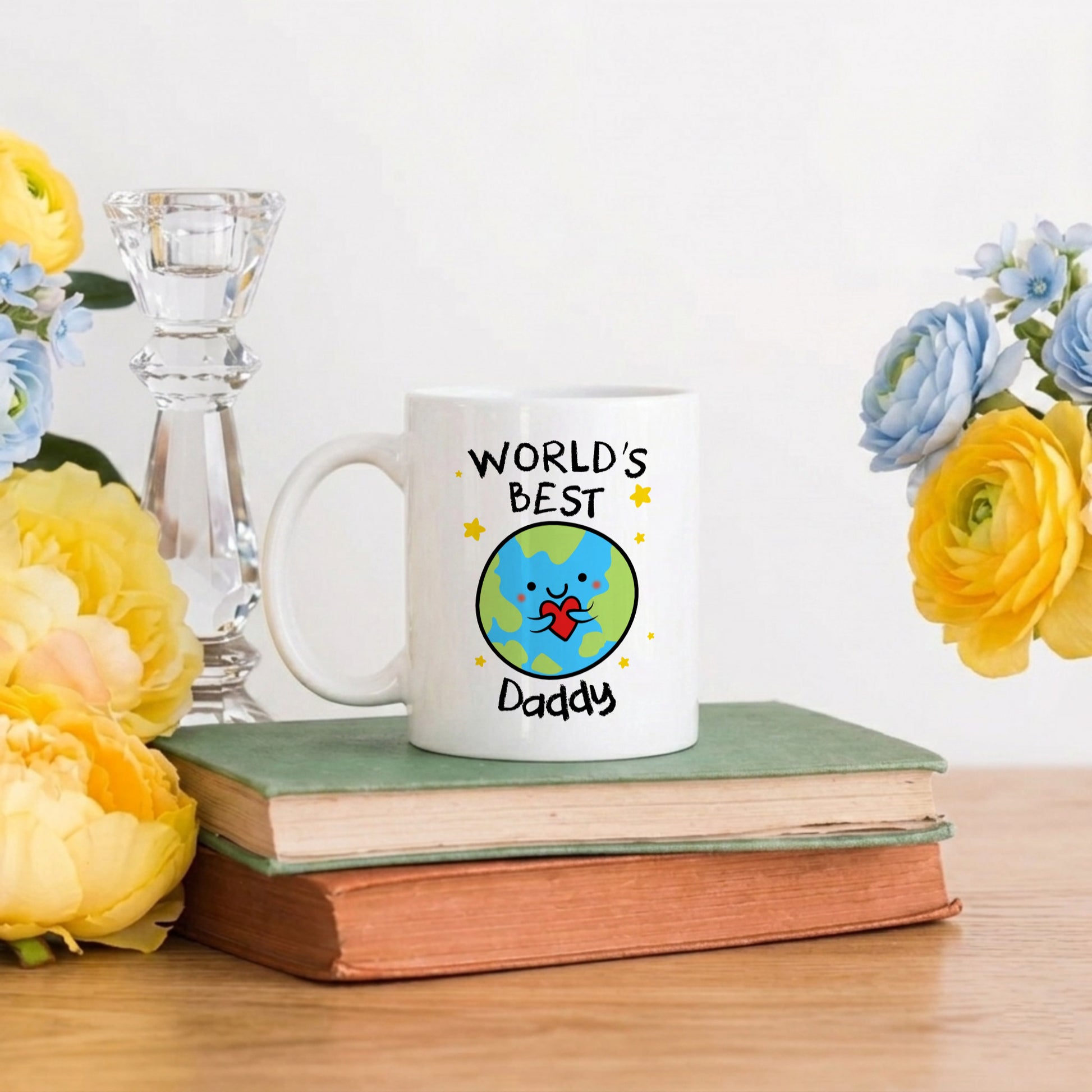 Mug with 'World's Best Daddy' design on a book with flowers and a candle in the background