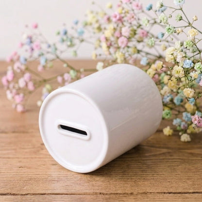 White cylindrical container on a wooden surface with pastel flowers in the background