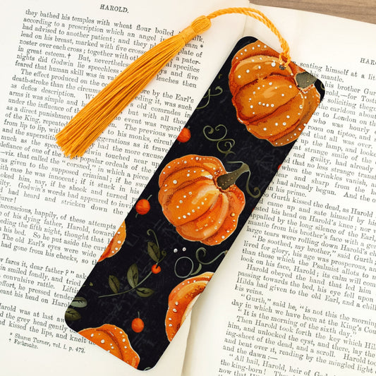 Decorative pumpkin-themed bookmark on an open book