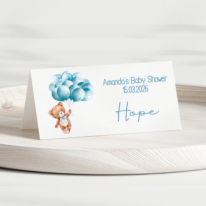 Baby shower invitation card with teddy bear and balloons on a white background