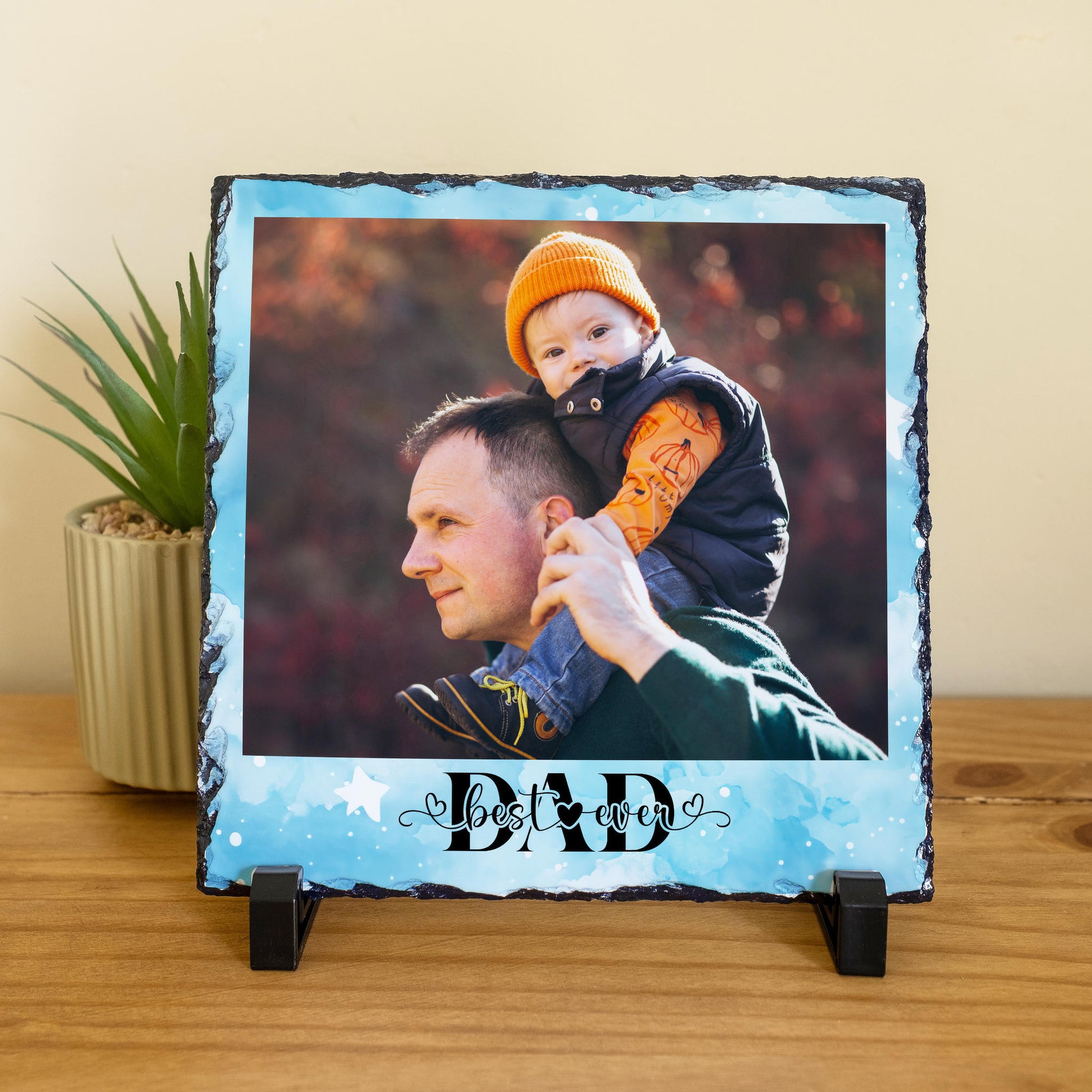 Personalised Best Ever Dad photo slate with blue watercolour background, showing a dad with baby on his shoulders, with two black display stands