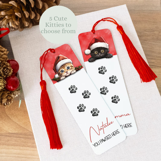 Personalized bookmark with cat design and red tassel on a wooden surface