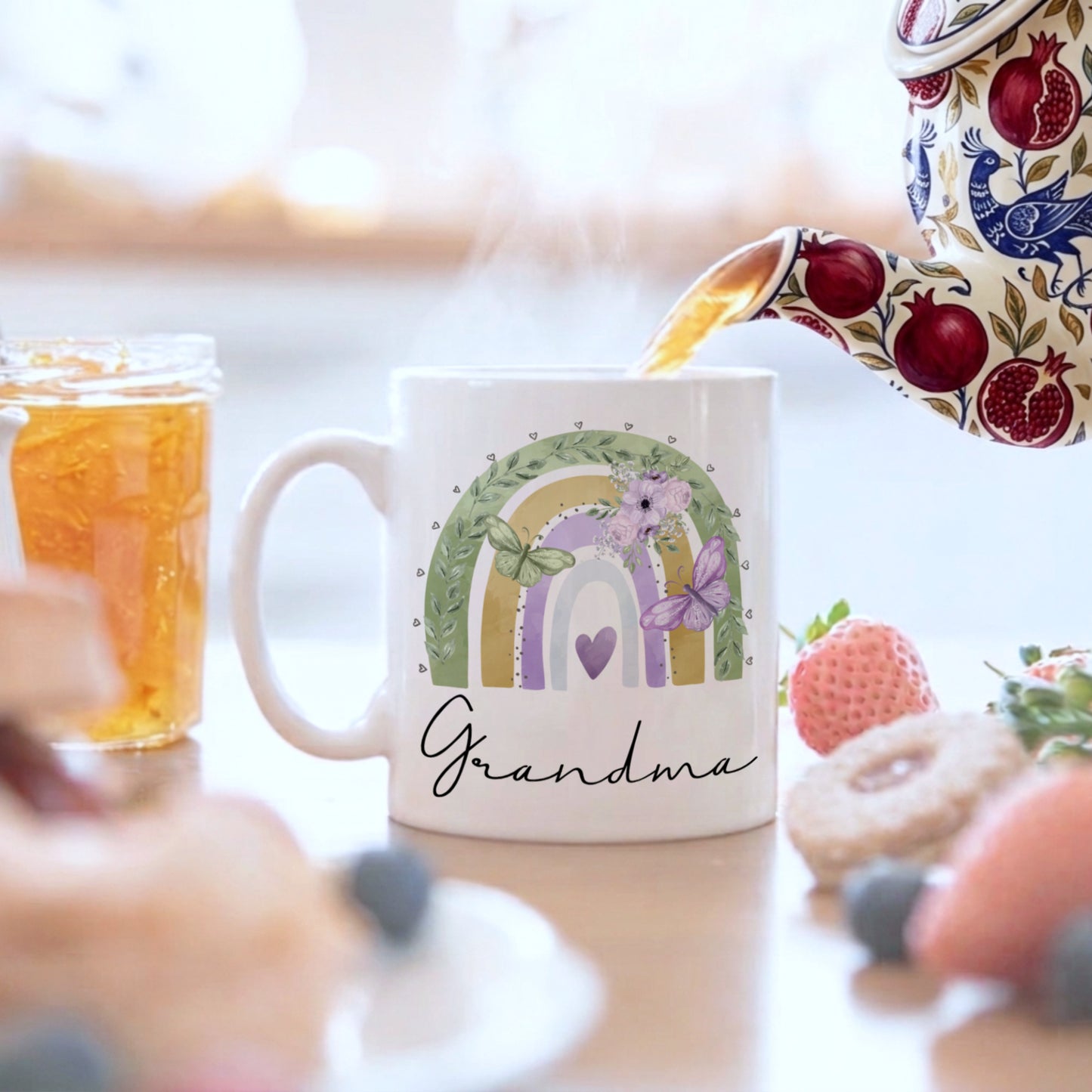 Mug with rainbow design and 'Grandma' text, being filled with tea.