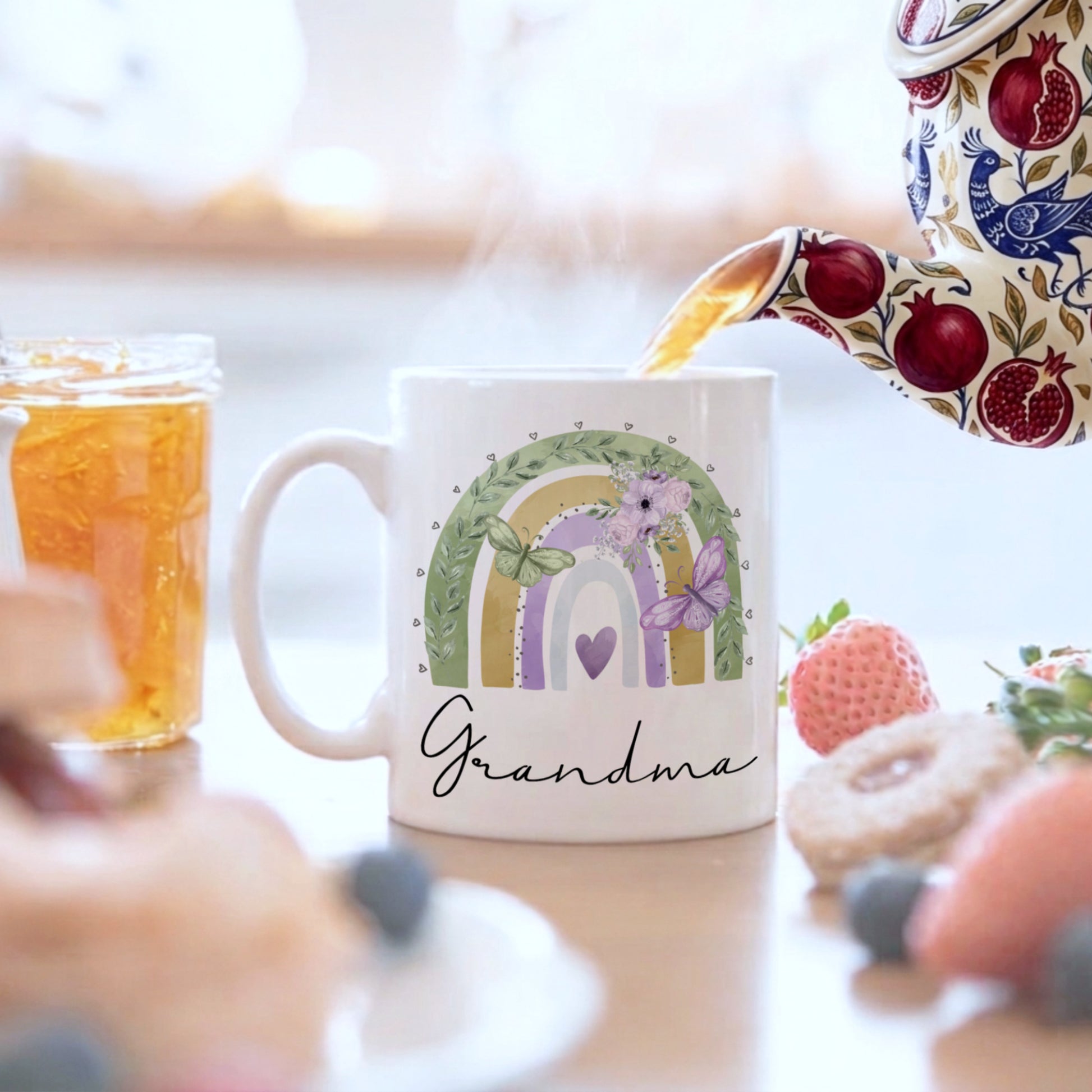 Mug with rainbow design and 'Grandma' text, being filled with tea.