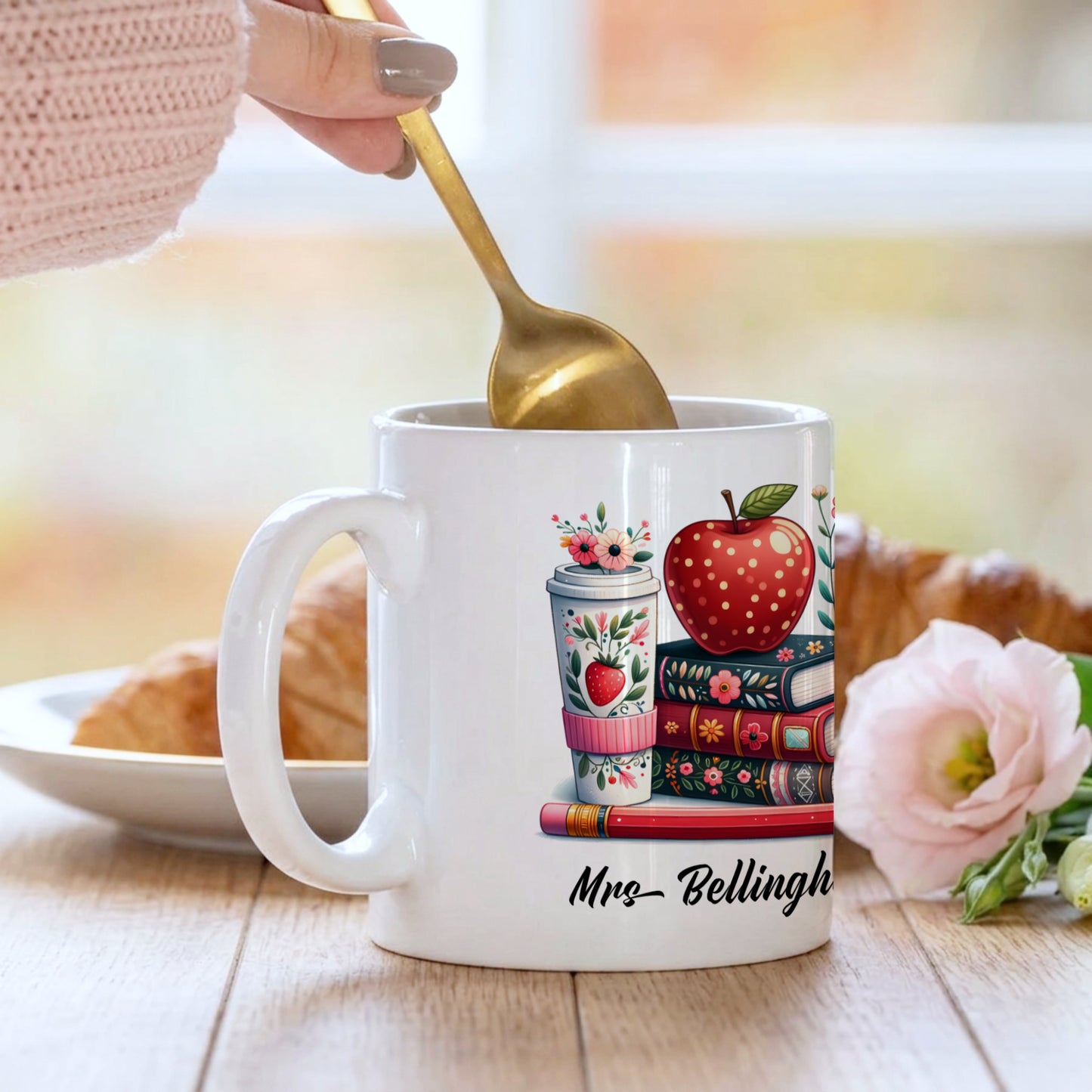 A woman stirring tea which is in a Personalised teacher mug with colourful stacked books and red apple design, customised with a teacher's name