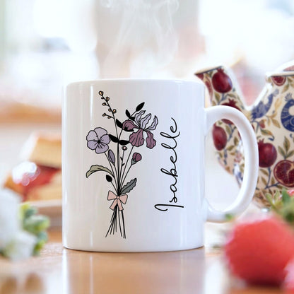 White mug with floral design and 'Isabelle' text on a blurred background