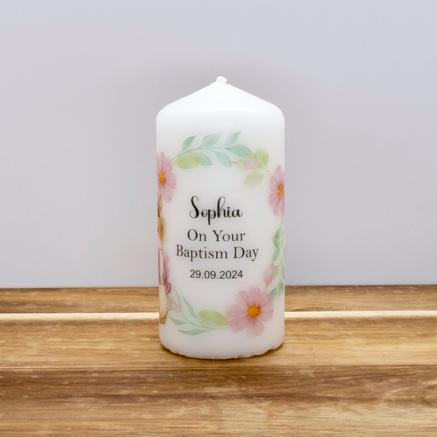 A white personalised taper candle with a floral border and the text 'Sophia On Your Baptism Day 29.09.