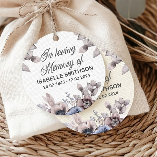 Memorial gift bag with personalized tag on a woven surface