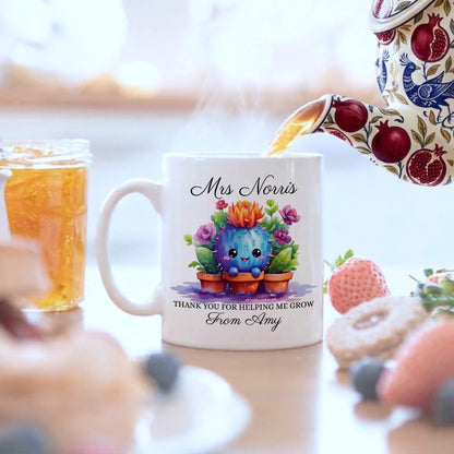 White ceramic personalised teacher gift mug featuring a smiling watercolour cactus with colourful flowers, personalised with teacher name 'Mrs Norris' and message 'Thank You For Helping Me Grow From Amy', with tea being poured from a floral teapot