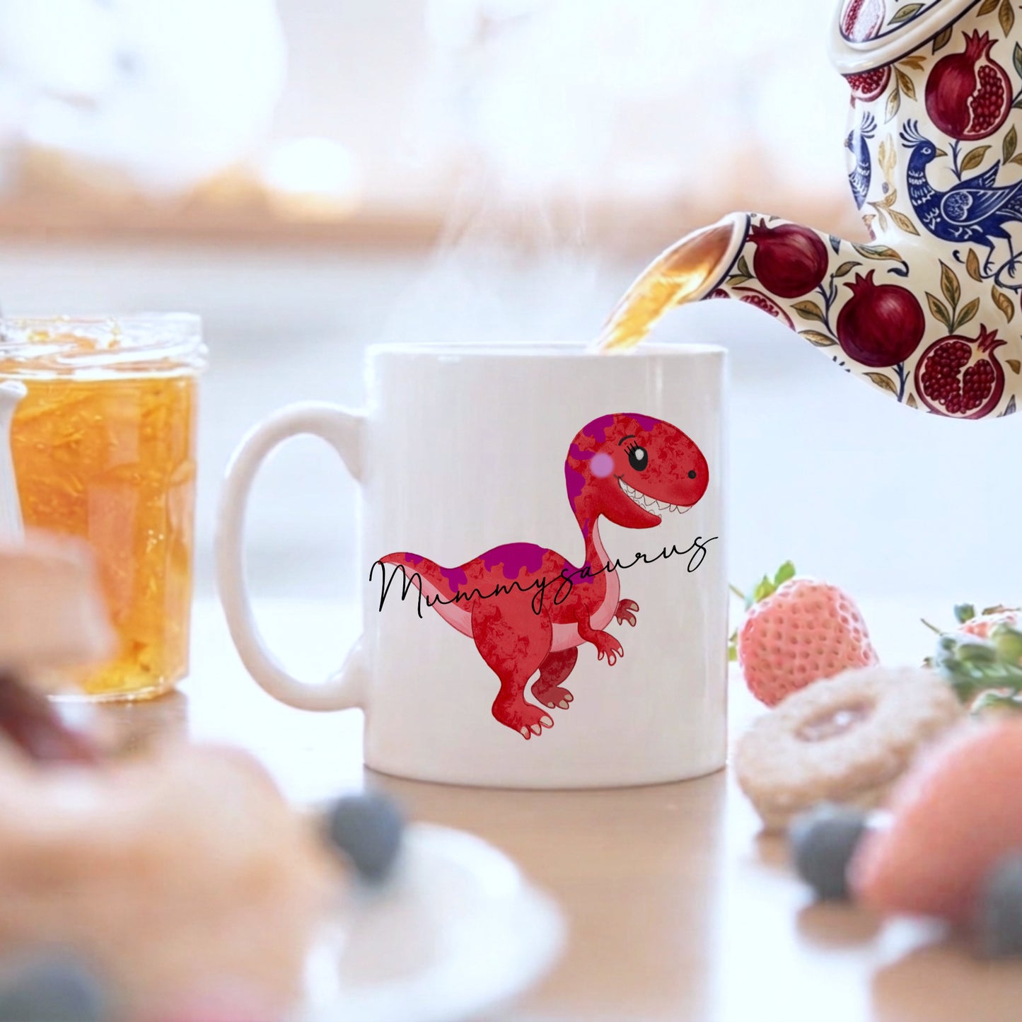White mug with a red dinosaur design with mummysaurus written on the dinosaur, on a breakfast table