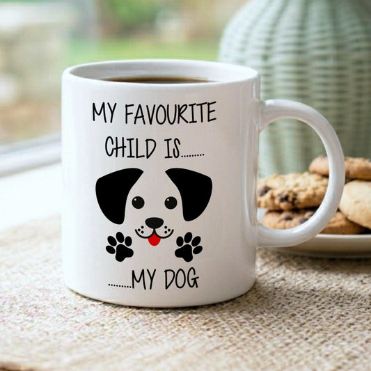 White mug with a dog illustration and text on a table with cookies and a vase in the background
