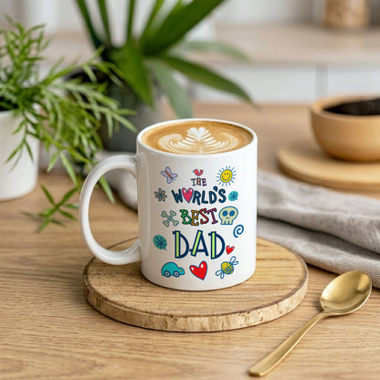 White mug with colorful text 'The World's Best Dad' on a wooden coaster with a plant and coffee in the background.