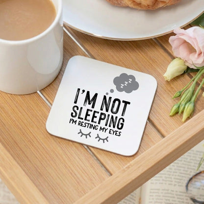 A coaster on a breakfast tray with the words I'm not sleeping