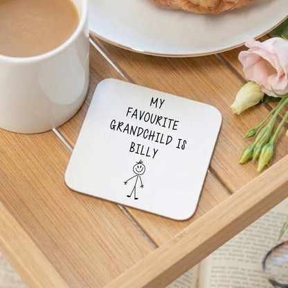 A white coaster with My favourite grandchild is Billy text, on a breakfast tray with a mug of tea, croissant and rose