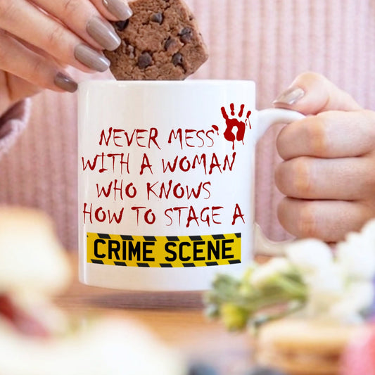 Person holding a mug with text and a cookie, blurred background