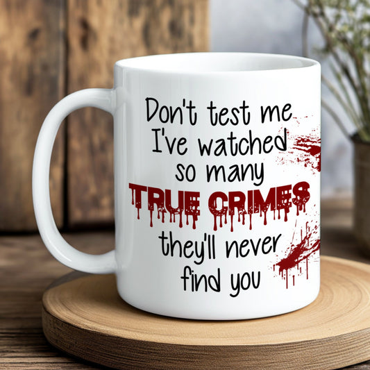 White mug with text and blood-like design on a wooden coaster