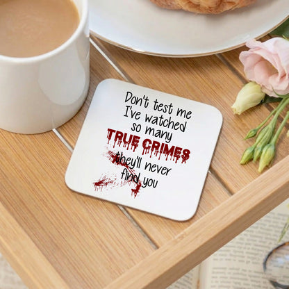 Coaster with text on a wooden table with a cup of coffee and flowers.