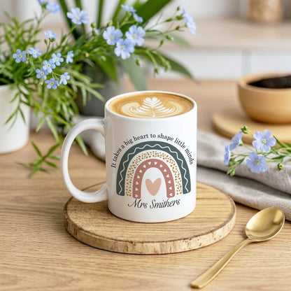 Mug with a design and text on a wooden coaster with flowers and a spoon in the background