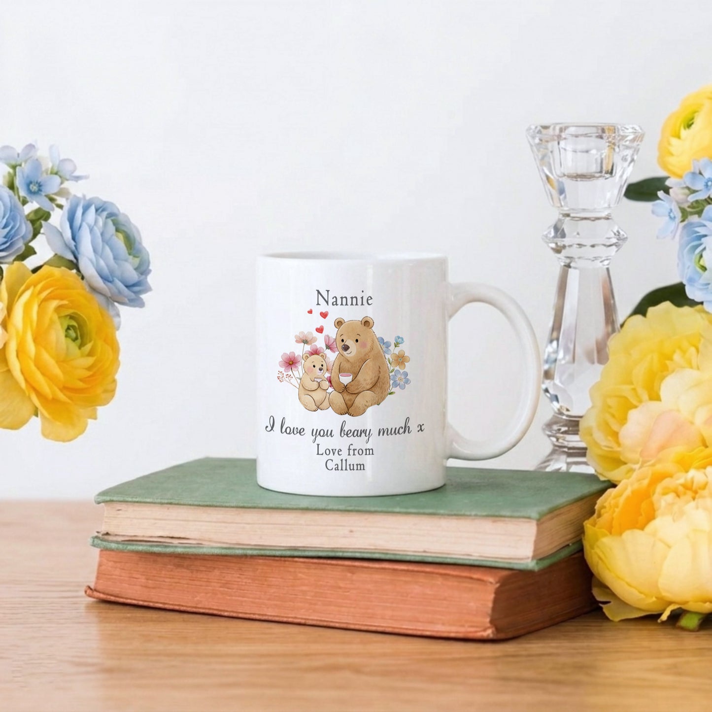 Personalized mug with teddy bear design on books with flowers and a candle holder.
