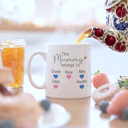 Mug with personalized text being filled with tea, surrounded by breakfast items.