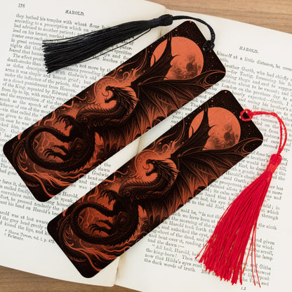 Two dragon-themed bookmarks with tassels on an open book.