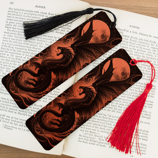 Two dragon-themed bookmarks with tassels on an open book.