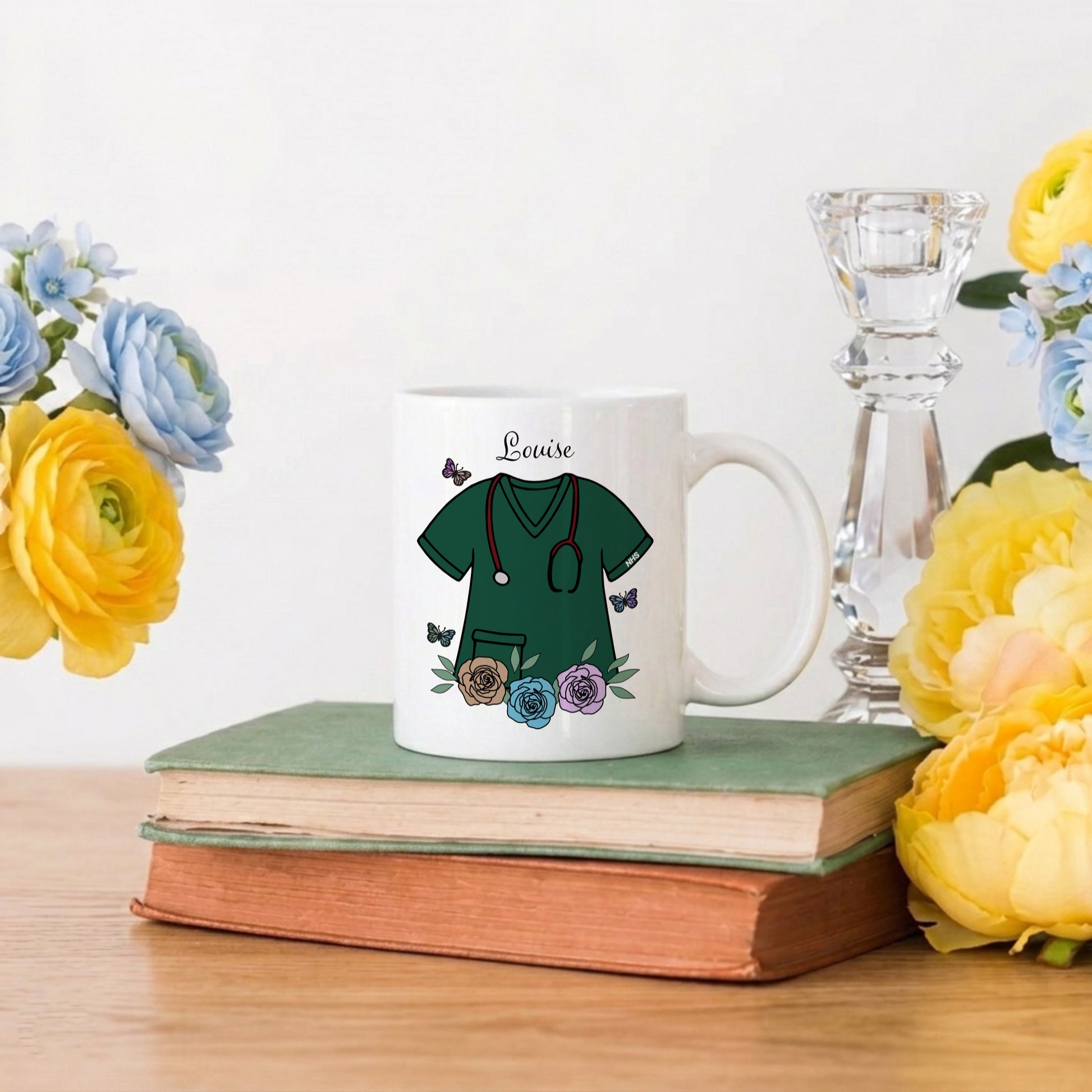 Mug with medical-themed design on a stack of books with flowers and a candle in the background