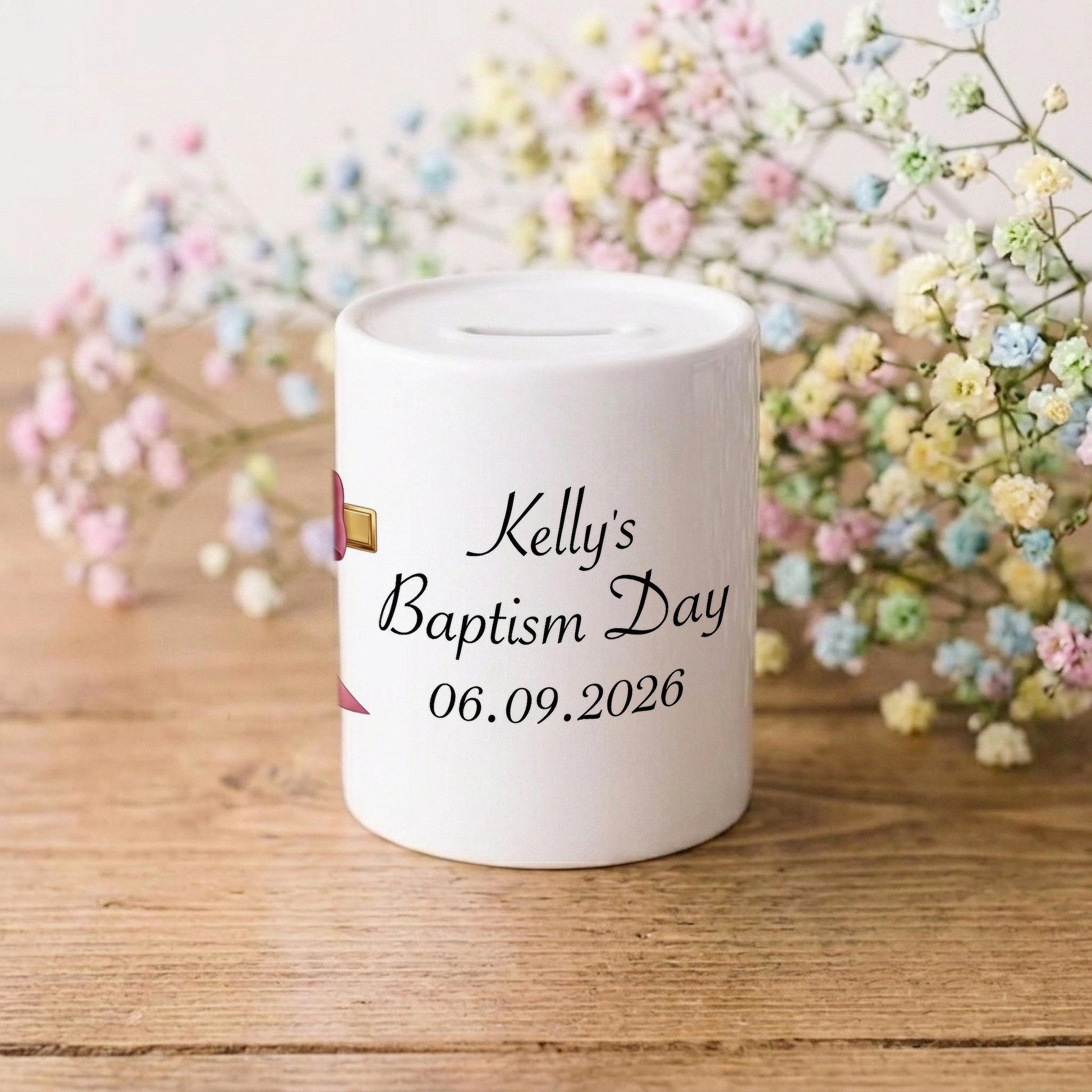 A white ceramic baby baptism money box with personalised text reading 'Kelly's Baptism Day 06.09.