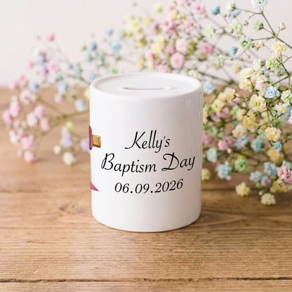 A white ceramic baby baptism money box with personalised text reading 'Kelly's Baptism Day 06.09.