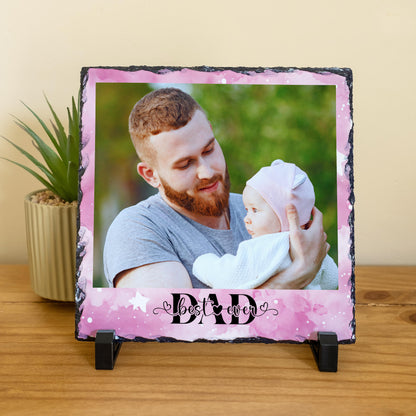 Personalised Best Ever Dad photo slate with pink watercolour background, showing a dad cradling a newborn baby, with two black display stands