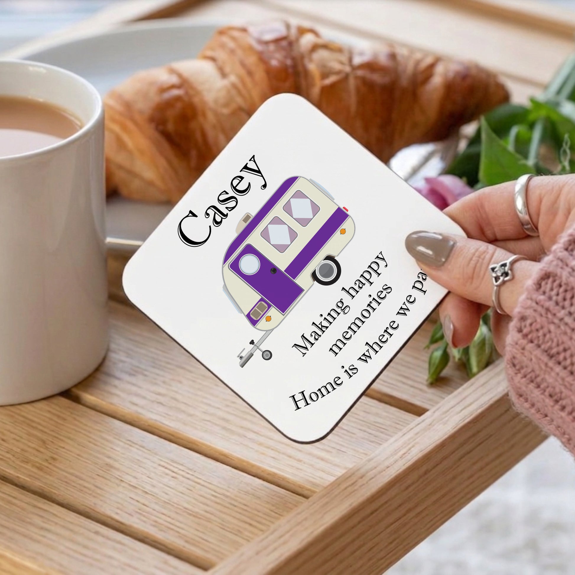 Coaster with 'Casey' design and text on a table with coffee and croissant
