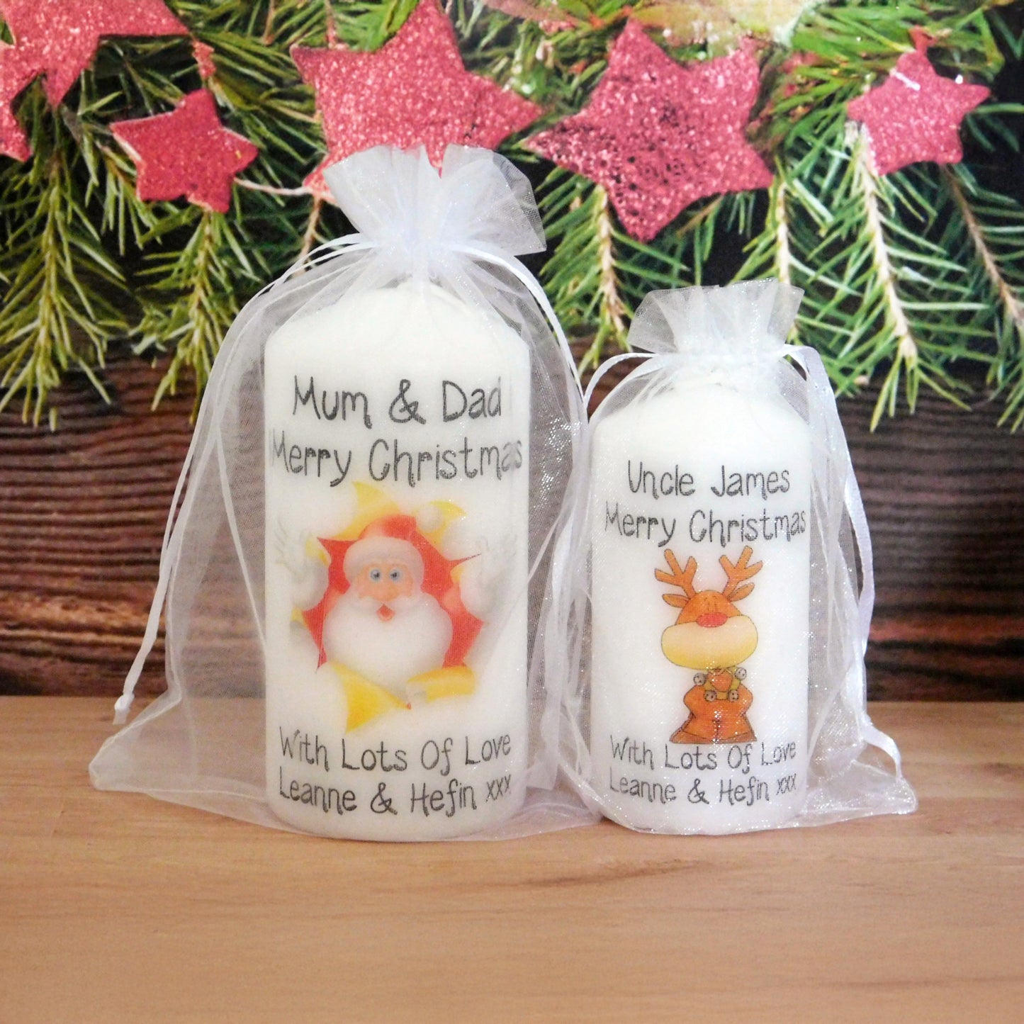 Two Christmas-themed candles in decorative bags with festive stars in the background.