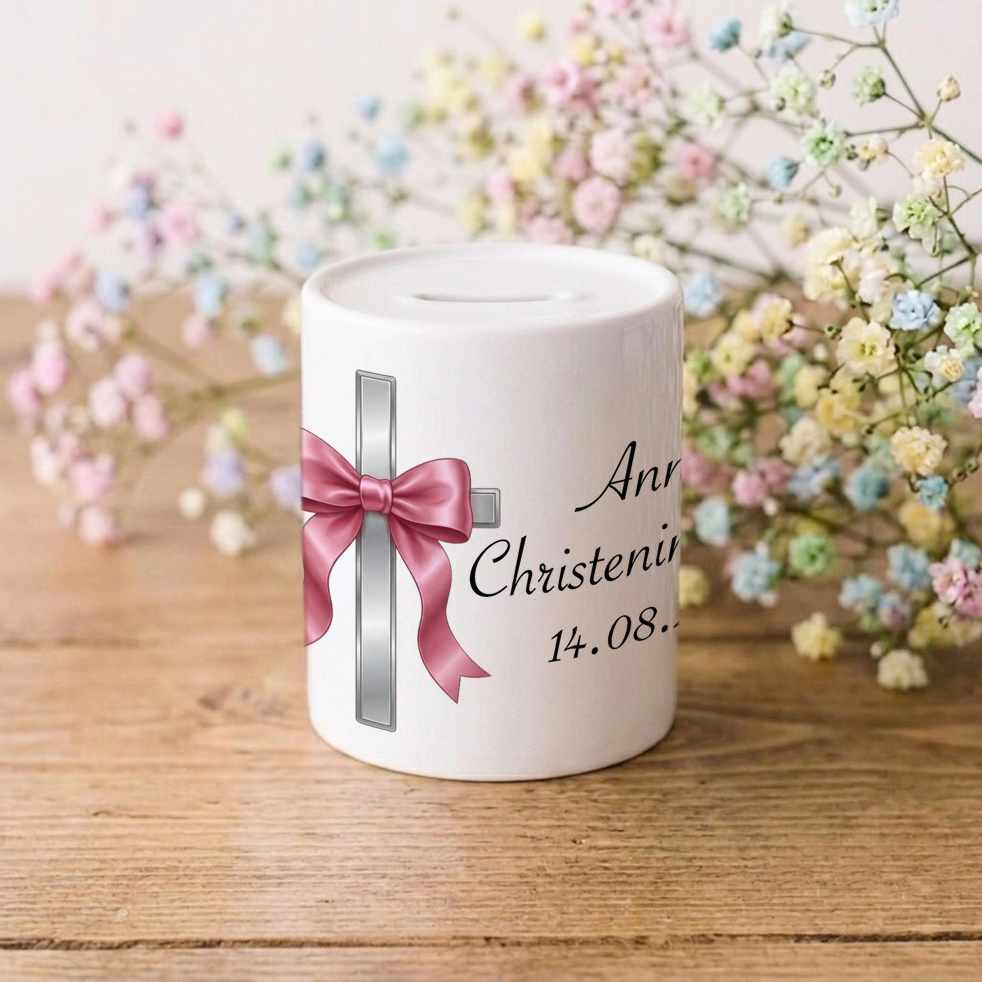 A white ceramic baby shower money box with a pink ribbon and silver cross design, personalised with the text 'Anna Christening 14.08.