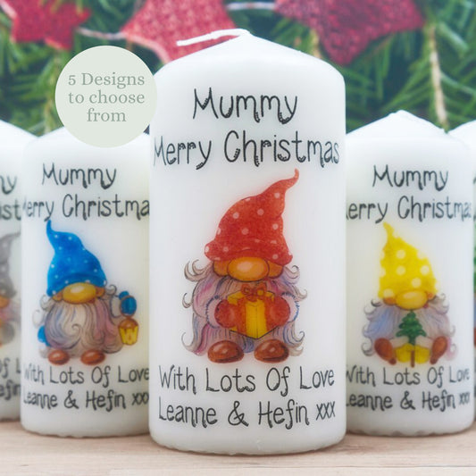 Decorative candles with gnomes and personalized text on a wooden surface.