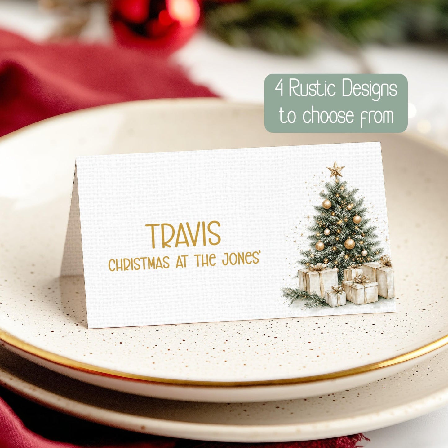A festive table place card with a gold name and a small Christmas tree illustration, displayed on a speckled ceramic plate with red fabric and holiday decorations in the background.