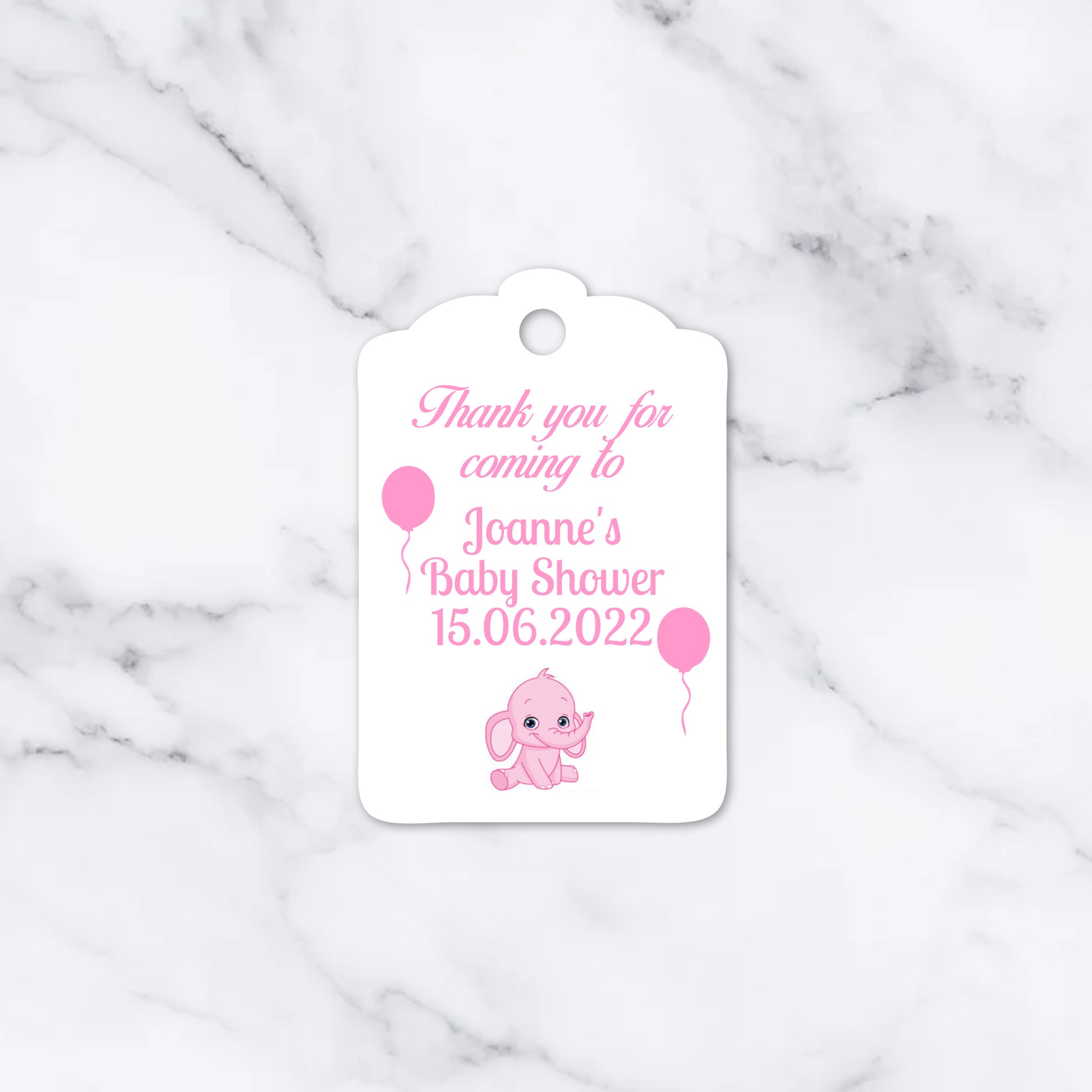A white paper gift tag with scalloped edges, featuring pink text that reads 'Thank you for coming to Joanne's Baby Shower 15.06.