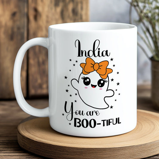 White mug with ghost design and text on a wooden coaster
