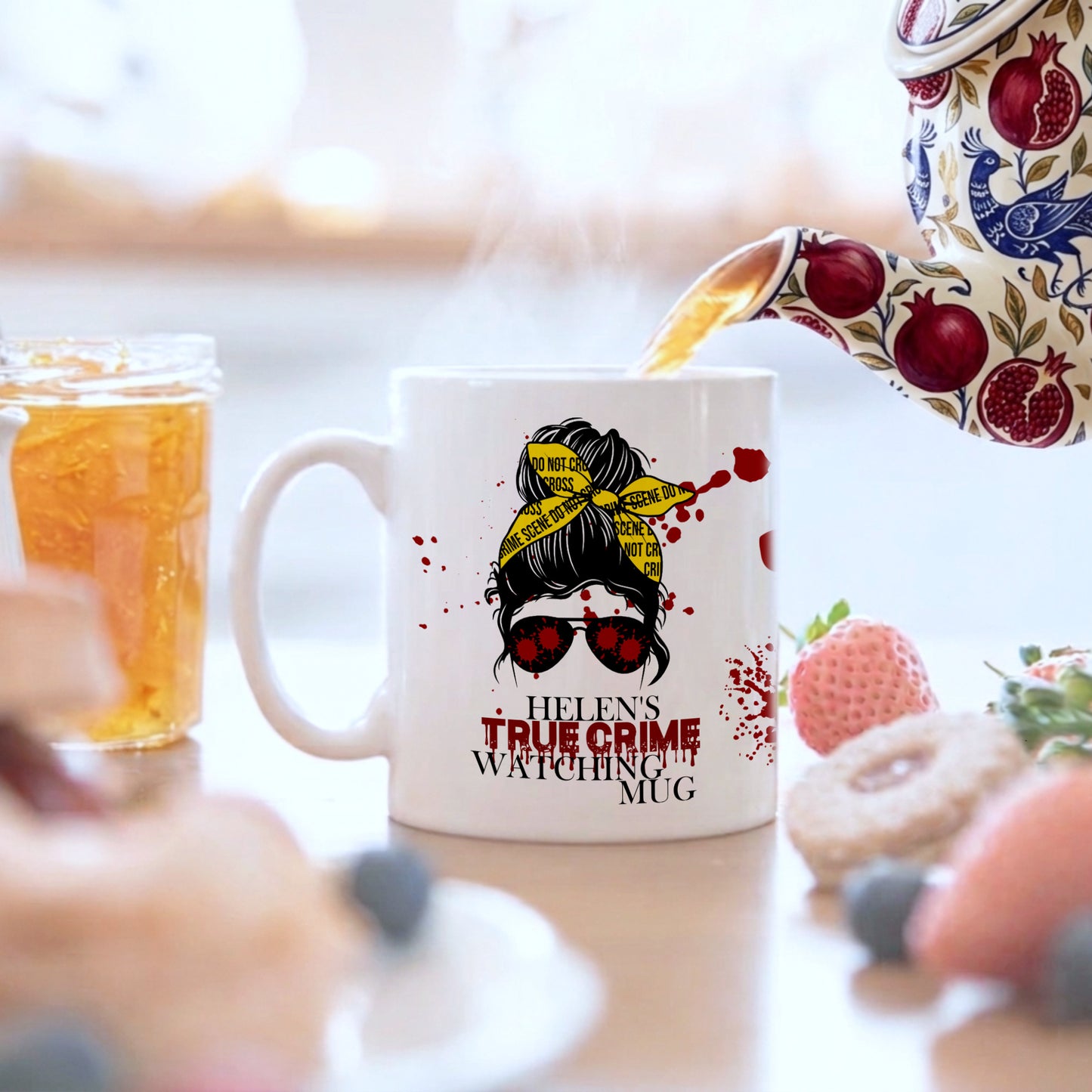 Mug with a design and text being filled with tea, surrounded by food items.