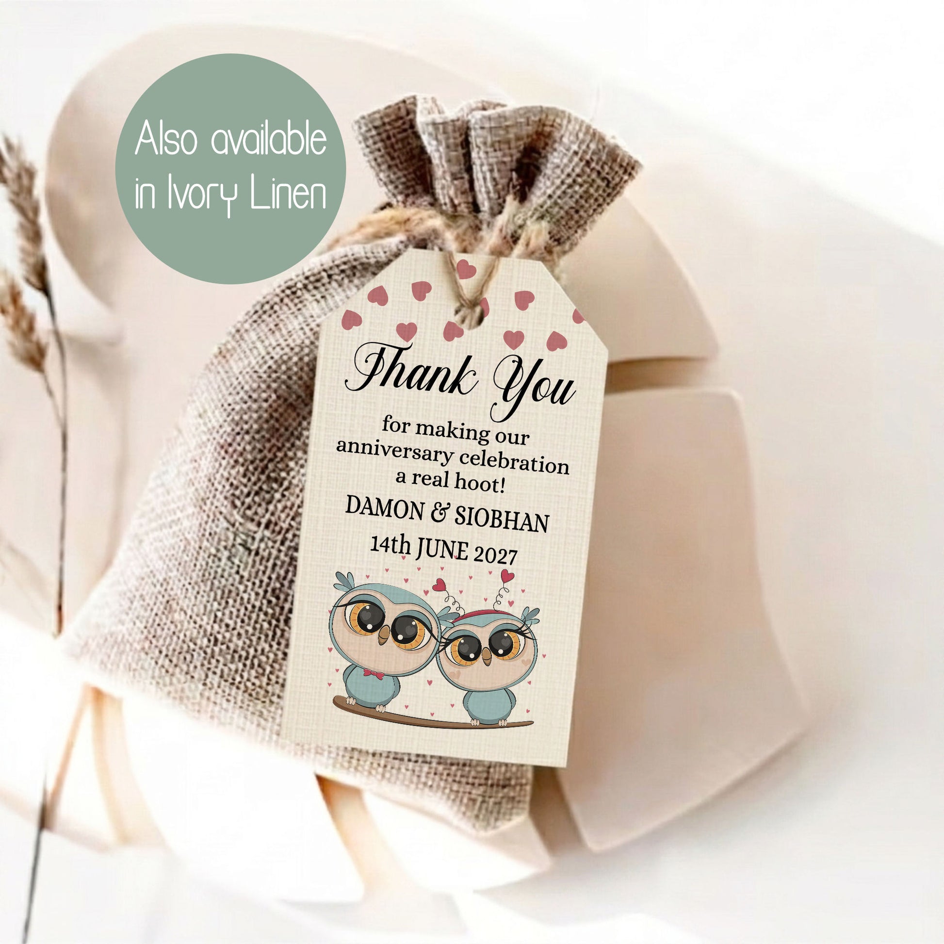 A burlap drawstring gift bag tied with twine, featuring a printed thank-you tag with pink hearts and cartoon owl illustrations. A green circular callout reads 'Also available in Ivory Linen.