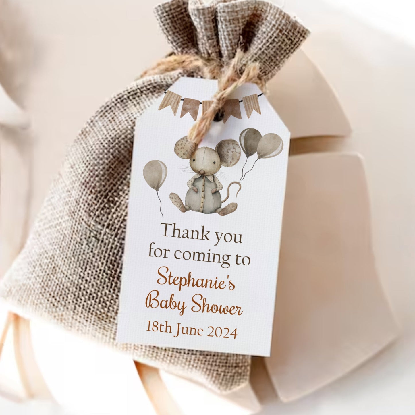 Gift bag with a decorative tag for a baby shower, featuring balloons and text.
