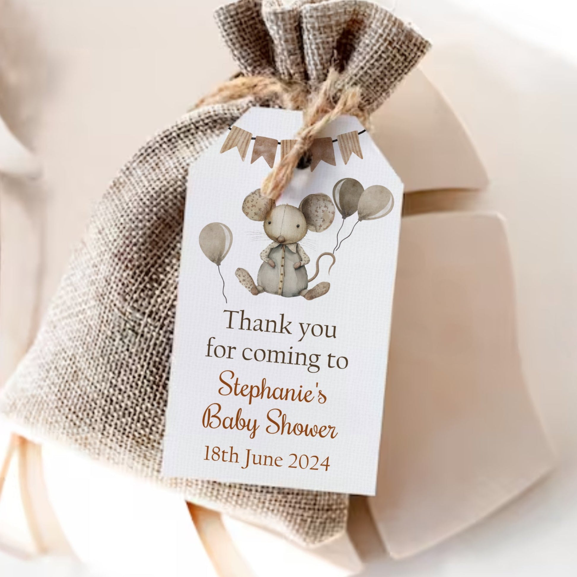 Gift bag with a decorative tag for a baby shower, featuring balloons and text.